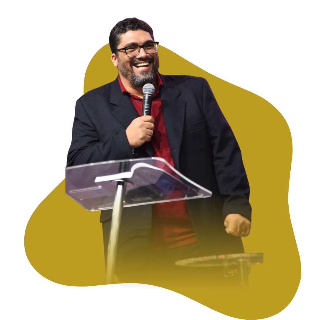 Pr felipe pansini pregando no pulpito com microfone na mão. está com um semblante feliz